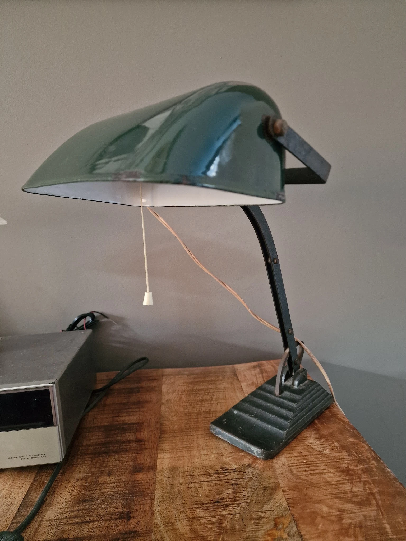 Groene bureaulamp met zwarte voet op houten tafel