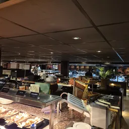 Overzicht van de winkelruimte met meubelstukken, stellingen en diverse spullen onder spotverlichting