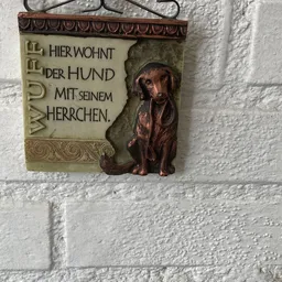 Bruin beeld van een teckel met Duitse tekst 'Hier wohnt der Hund mit seinem Herrchen'