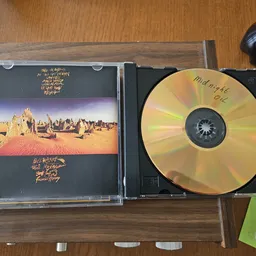 Geopende CD-case met muziek-cd en inlay met woestijnlandschap