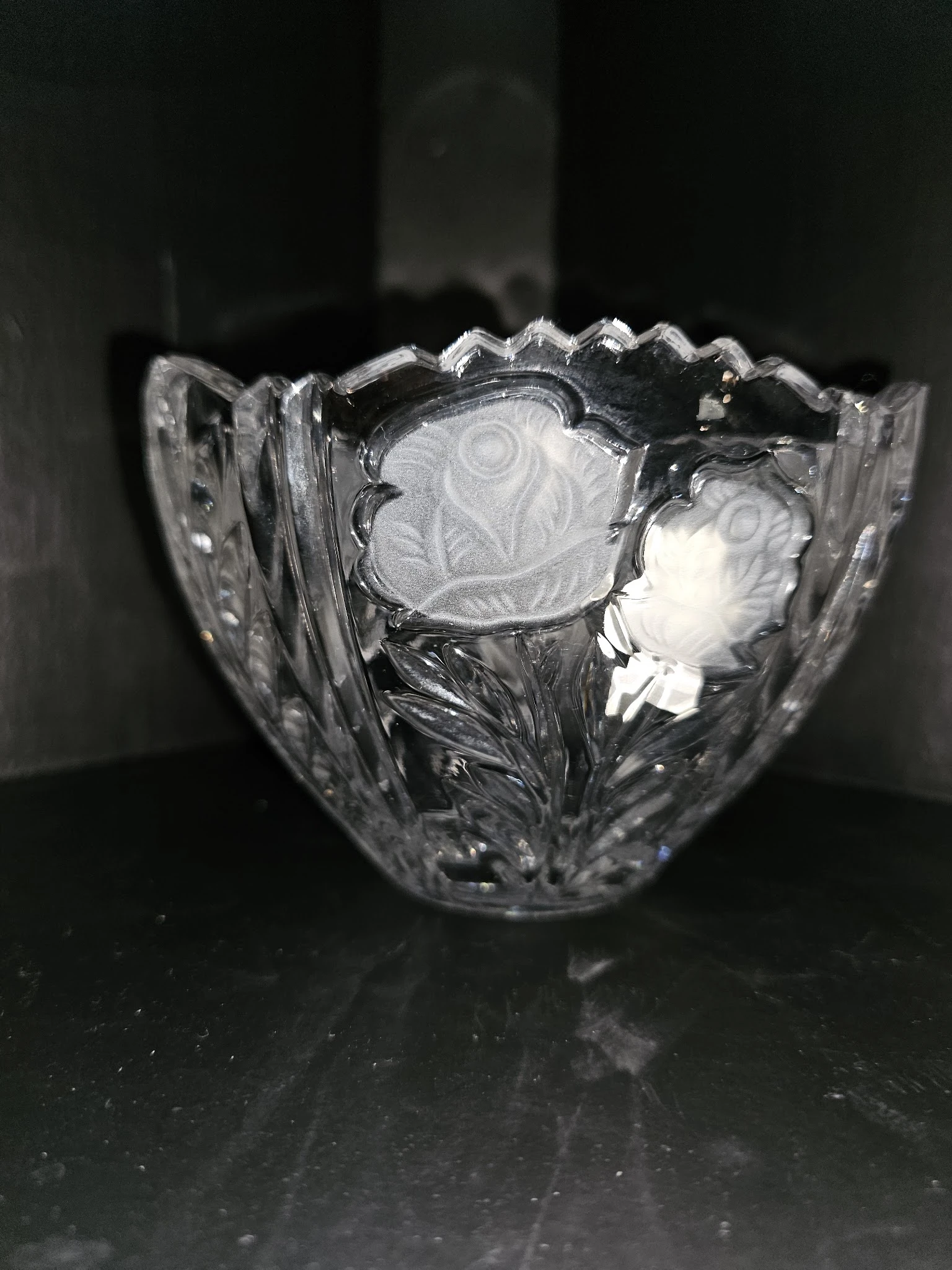 Close-up van een kristallen schaal met decoratief patroon en golvende rand