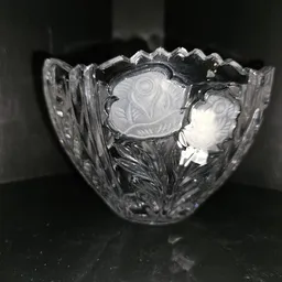 Close-up van een kristallen schaal met decoratief patroon en golvende rand