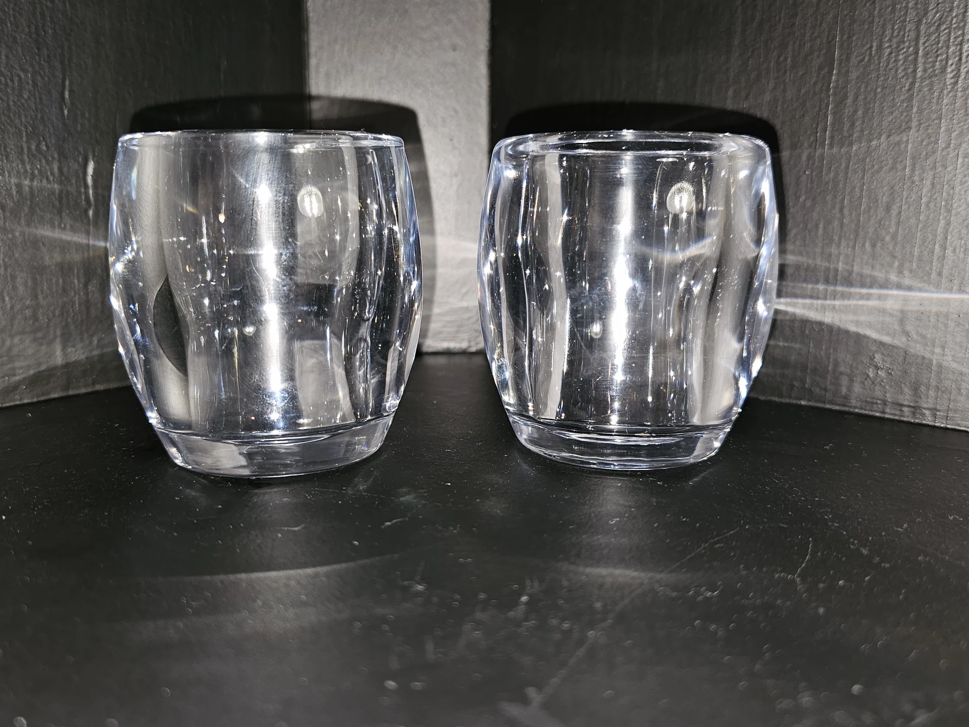 Twee glazen bekers zonder markering op donker aanrechtblad