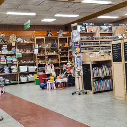 Winkelvloer met stellingen, kinderhoek met speelgoed en boeken in kringloopwinkel