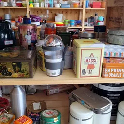 Kringloopwinkel stellage met huishoudelijke artikelen, keukengerei en dozen