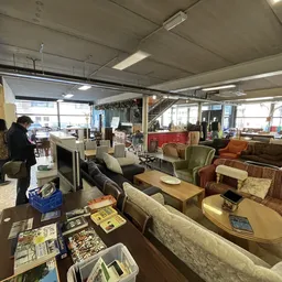 Ruime winkelvloer van kringloopwinkel met diverse meubels, fauteuils en banken op display