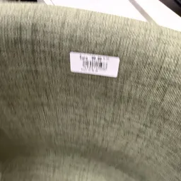 Prijssticker met barcode op grijze textielstof