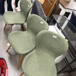 Drie groene stoelen met houten poten op het winkelinterieur
