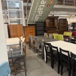 Winkelvloer met uitgestalde meubels, tafels met stoelen en kasten tegen de wand