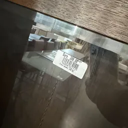 Prijssticker met barcode op glazen artikel in winkel