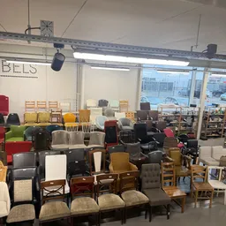 Grote collectie tweedehands stoelen en fauteuils in verschillende kleuren en stijlen in de winkel