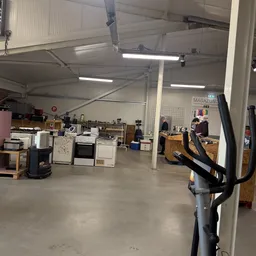 Overzicht van de winkelvloer met verschillende elektronische apparaten, huishoudapparaten en andere goederen uitgestald