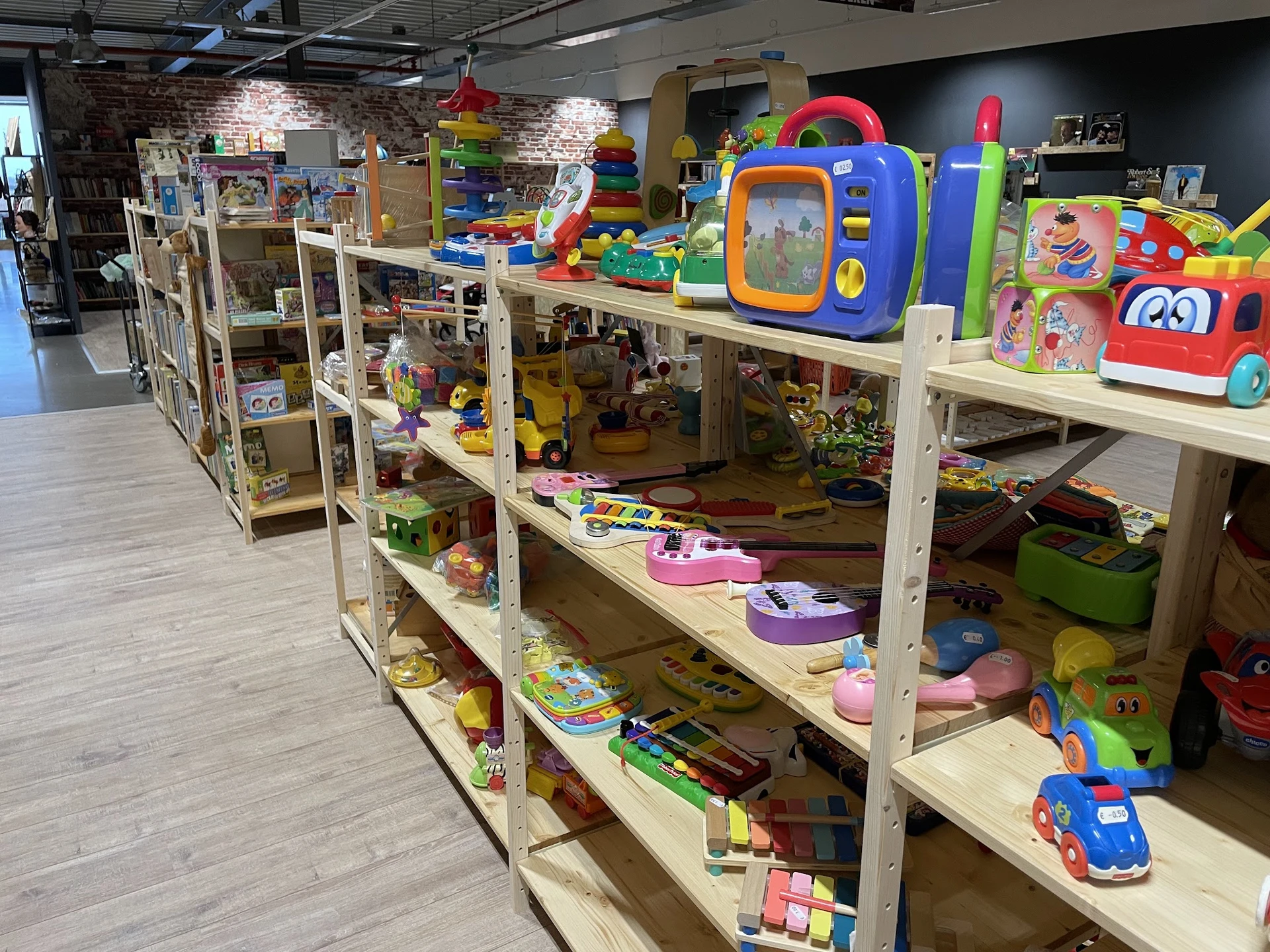 Houten stellingen met speelgoed en kinderspeelgoed in diverse kleuren en types uitgestald