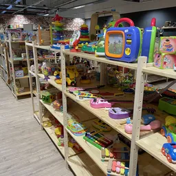Houten stellingen met speelgoed en kinderspeelgoed in diverse kleuren en types uitgestald