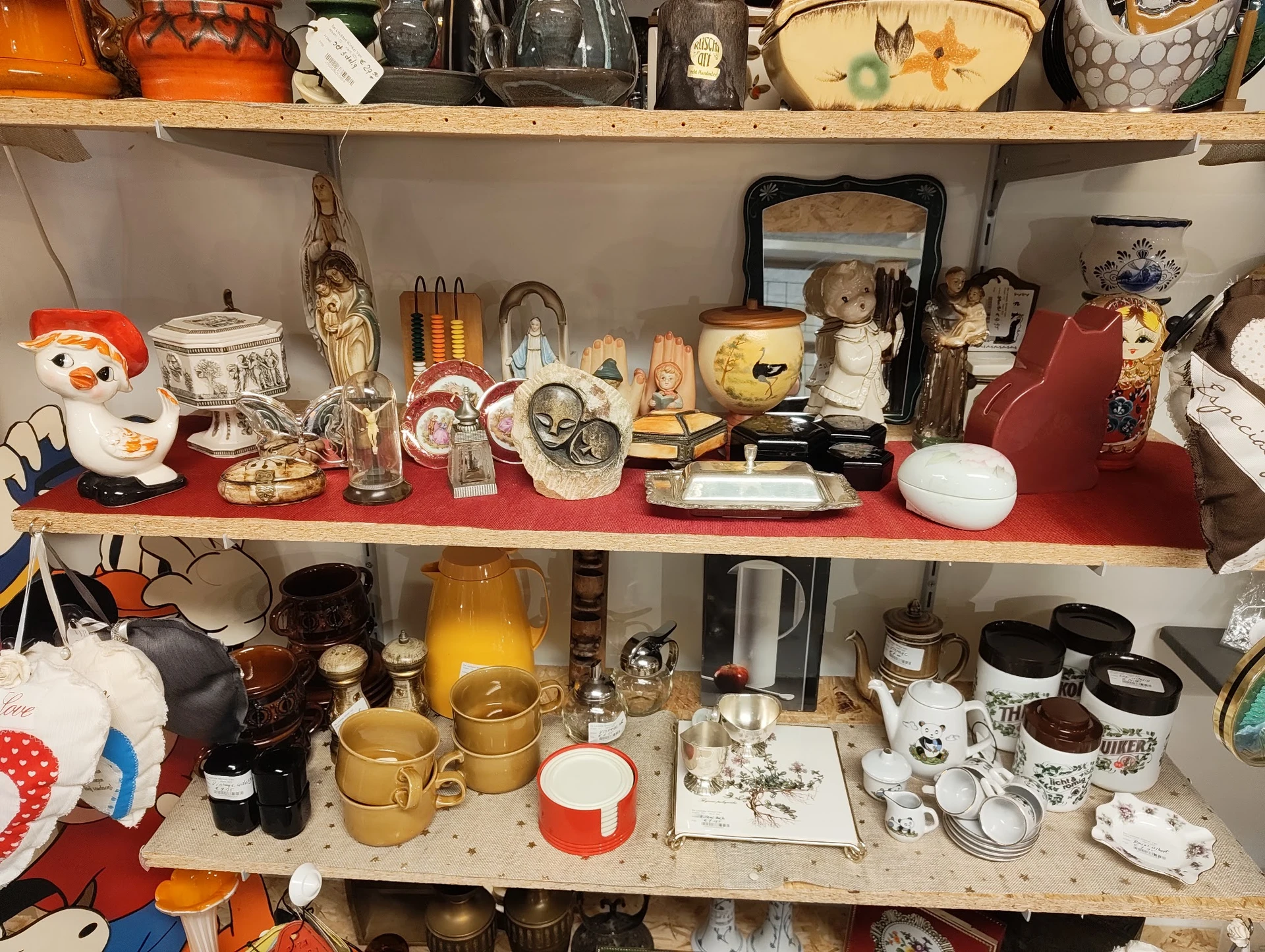 Schappen met tweedehands huishoudartikelen, servies, decoratie en diverse spullen uitgestald