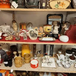 Schappen met tweedehands huishoudartikelen, servies, decoratie en diverse spullen uitgestald