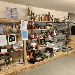 Stellingen vol met tweedehands spullen, beeldjes, decoratie-artikelen en huishoudgoederen in een kringloopwinkel