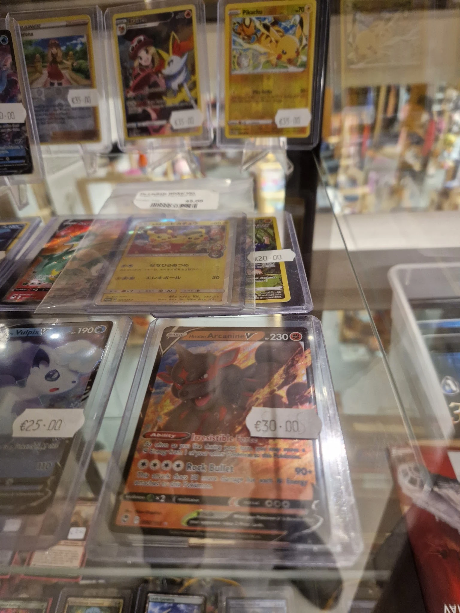 Verzameling van in plastic hoezen verpakte verzamelkaarten met prijskaartjes in een vitrine