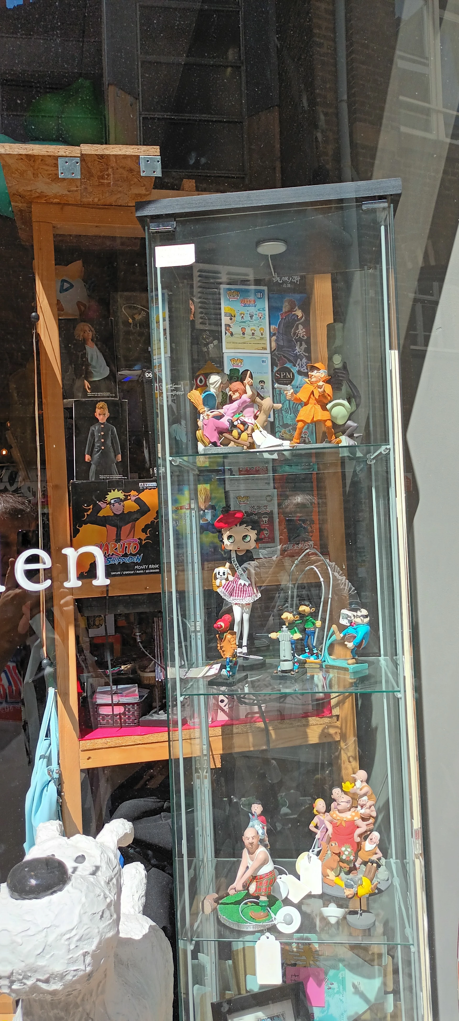 Vitrine met verzameling anime- en manga-figuren en poppen op verschillende niveaus