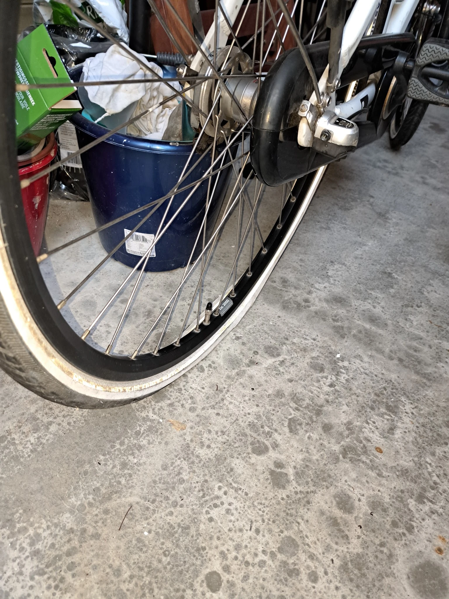 Fietsachterwiel met spaken en banden tegen betonnen ondergrond