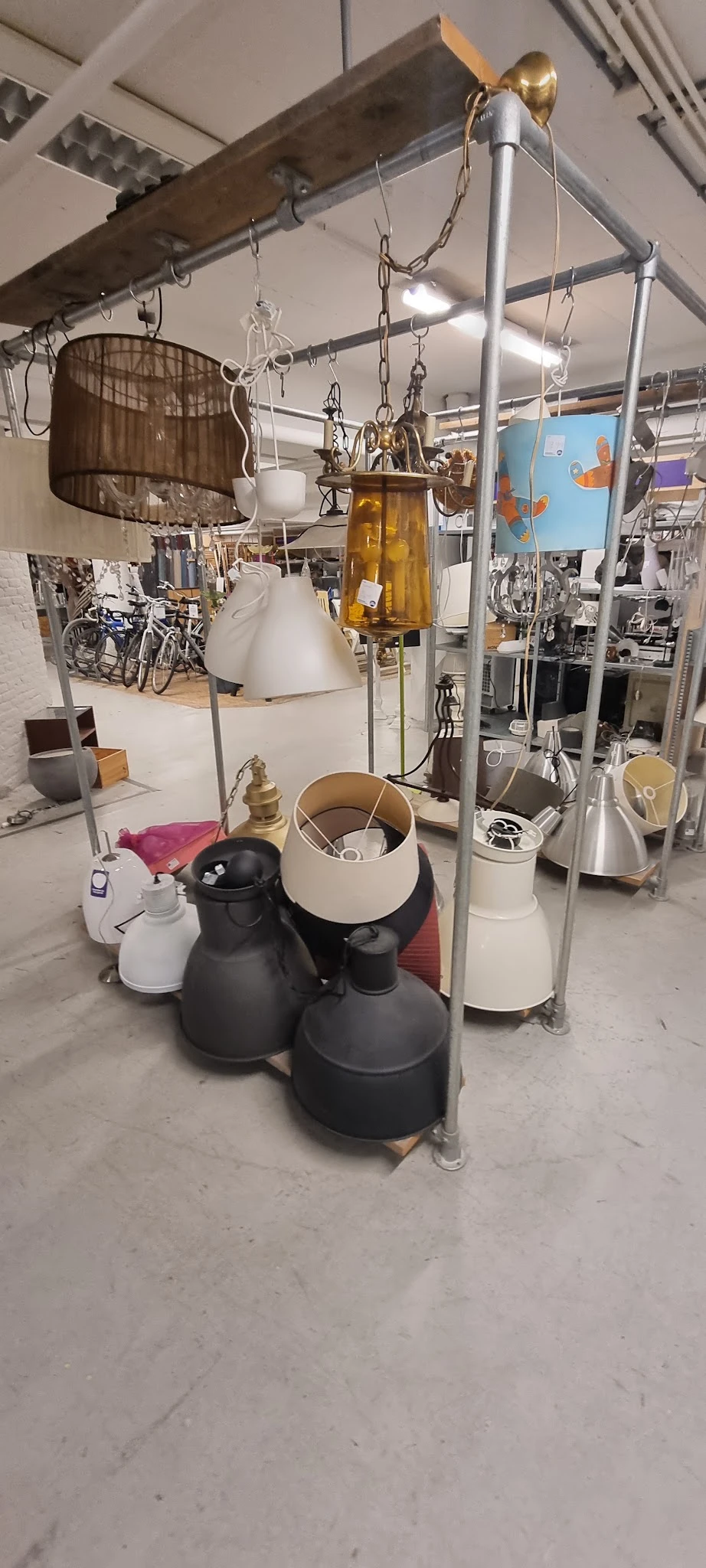 Verzameling tweedehands lampen en verlichting op de winkelvloer van een kringloopwinkel