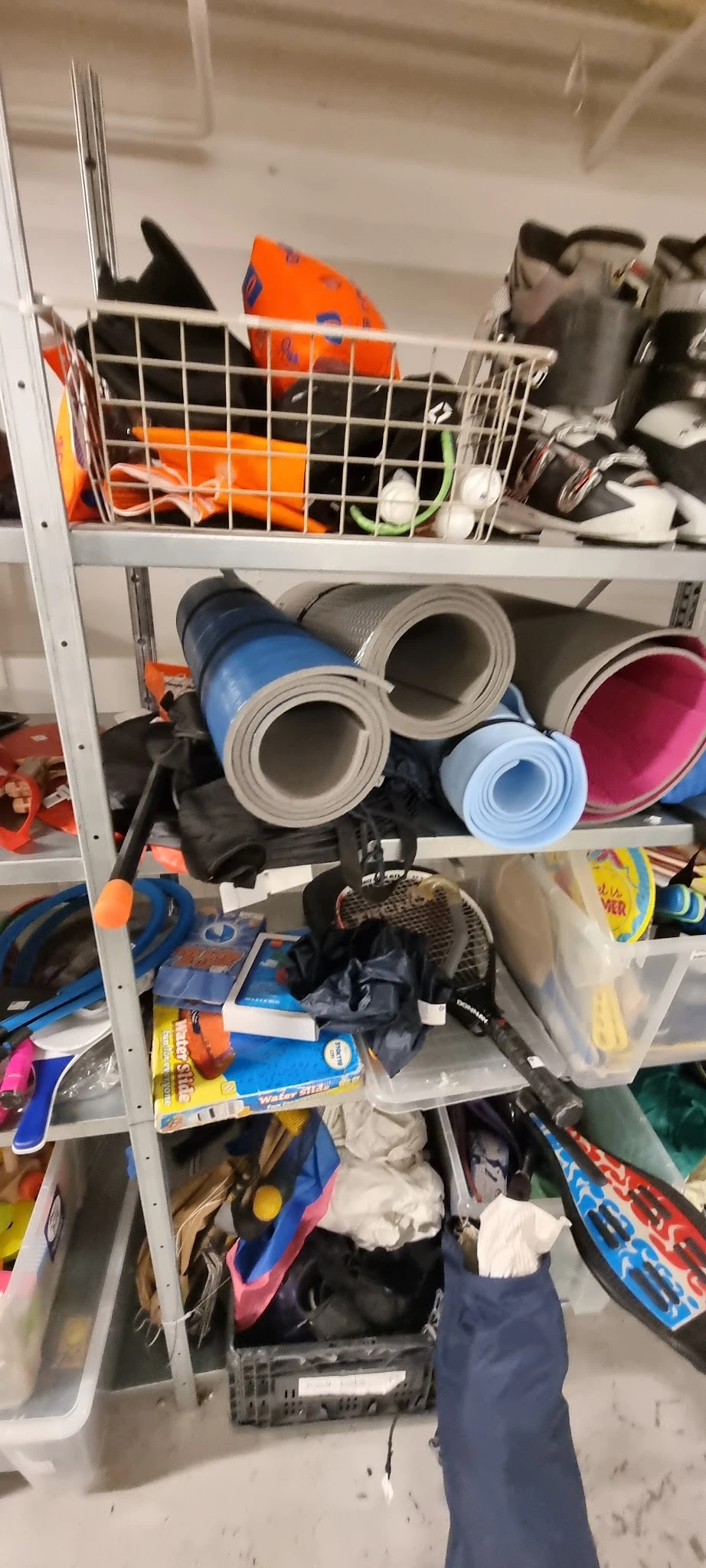 Verschillende opgerolde matten en vloerbedekking in verschillende kleuren op een stellingkast