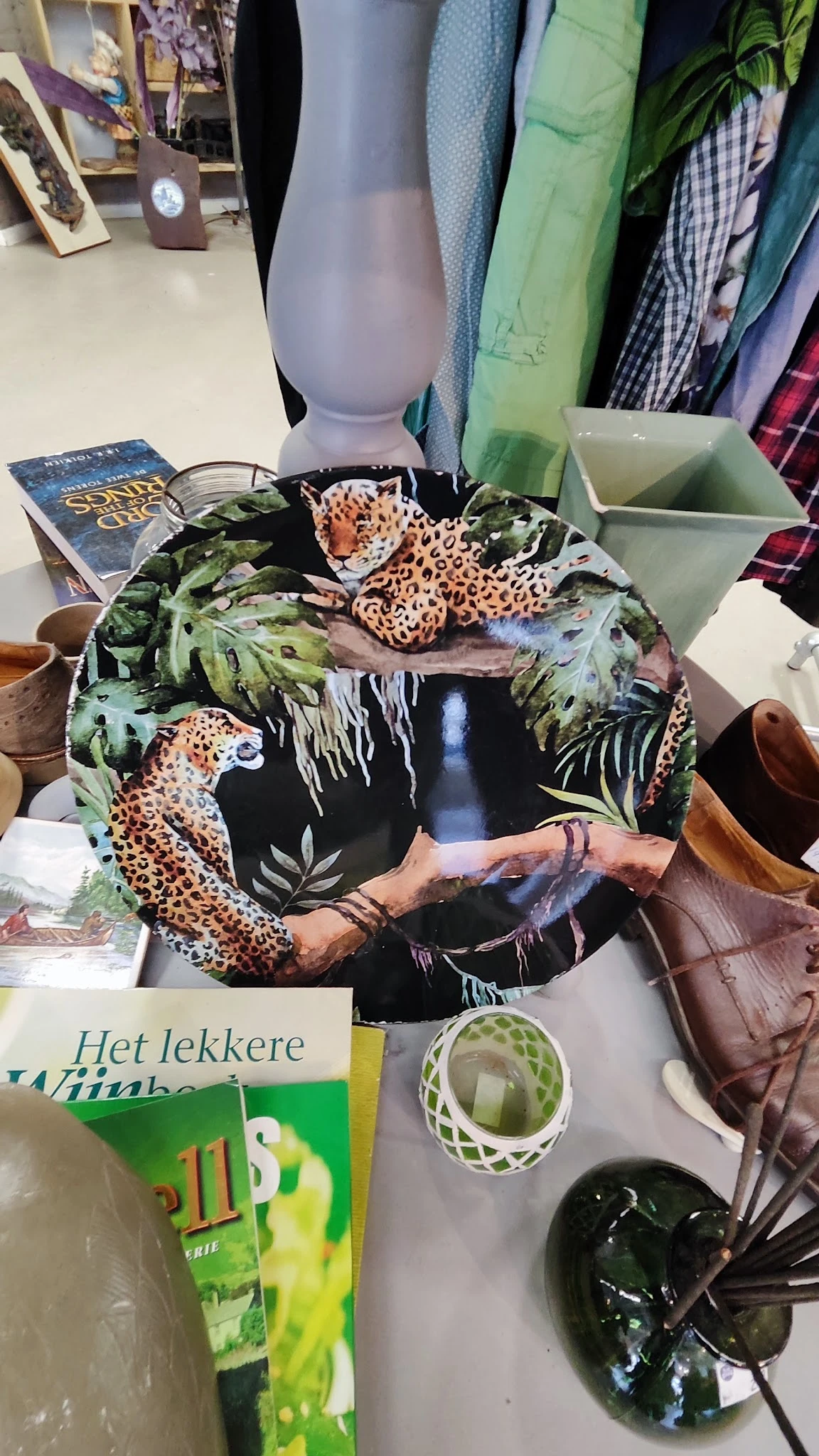 Decoratief rond bord met luipaarden en tropische bladeren op zwarte achtergrond