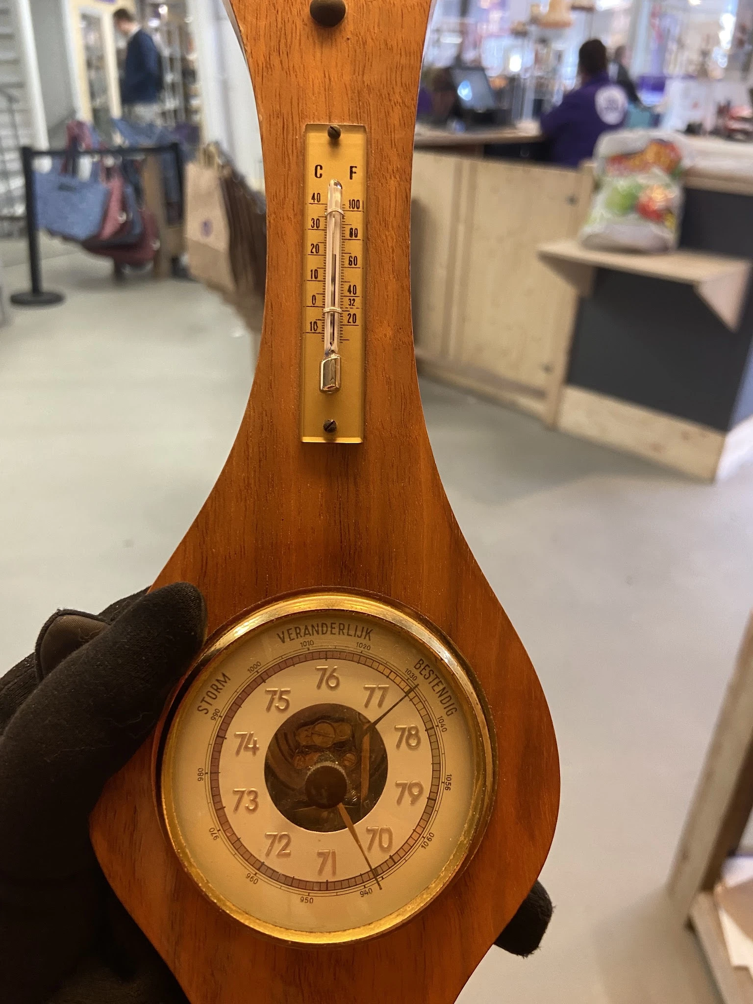 Close-up van een houten barometer met messing details en thermometer