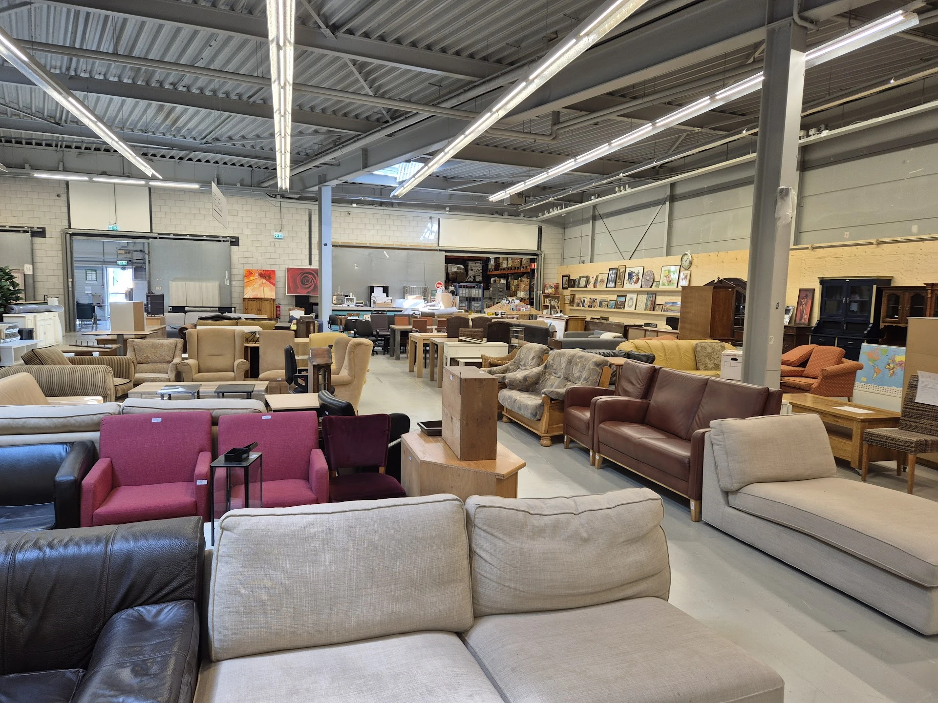 Ruim interieur met diverse meubels: banken, stoelen en fauteuils in verschillende kleuren en stijlen
