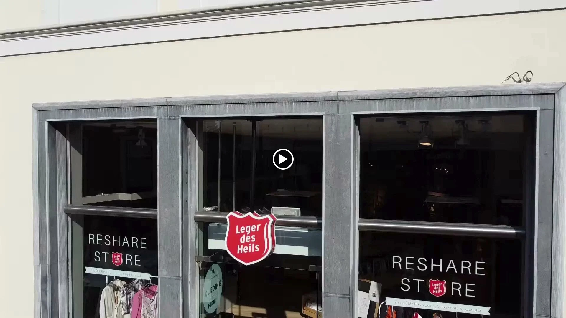 Winkelgevel met glazen deuren, 'RESHARE STORE' opschrift en logo van Leger des Heils