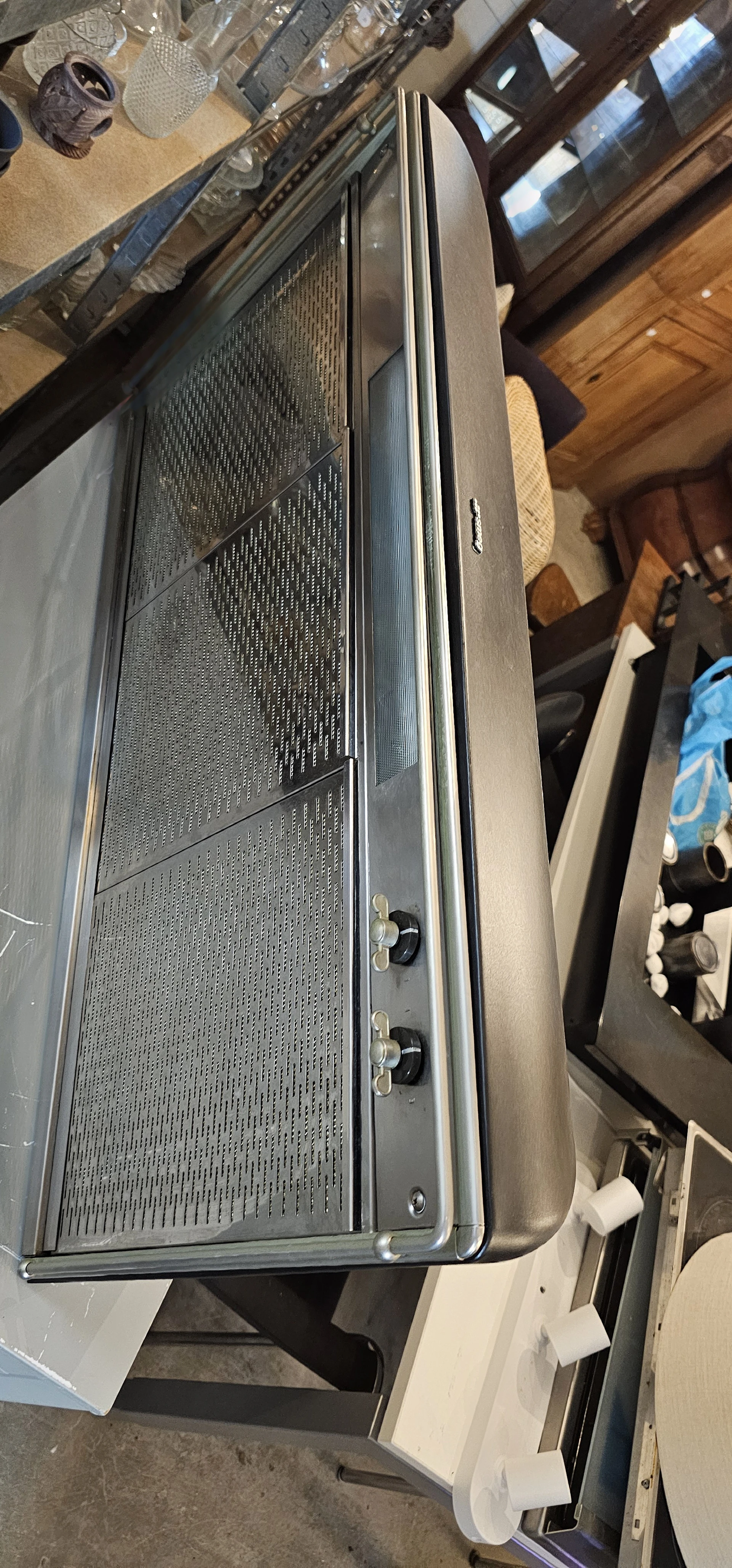 Close-up van een microwave of elektrisch keukenapparaat met metalen grille en bedieningsknoppen