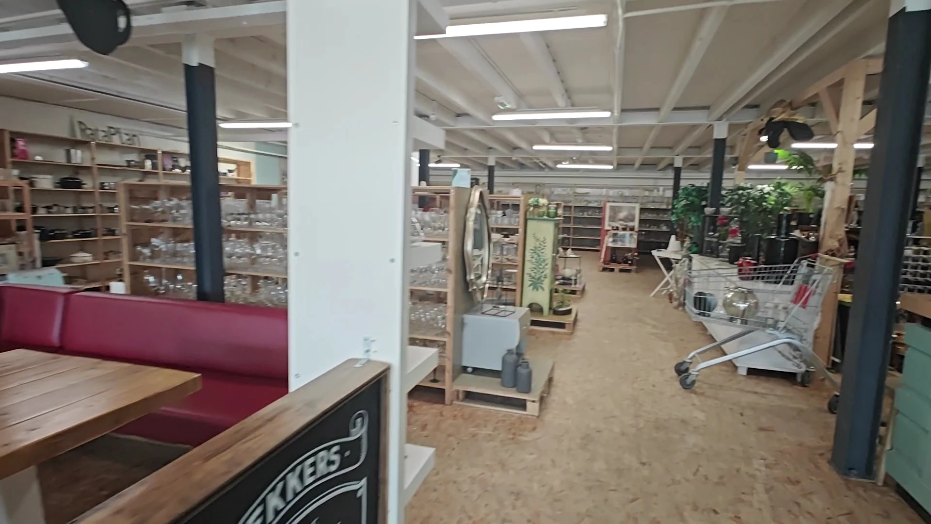 Winkelvloer met stellingen, rekken en uitgestalde spullen in een kringloopwinkel