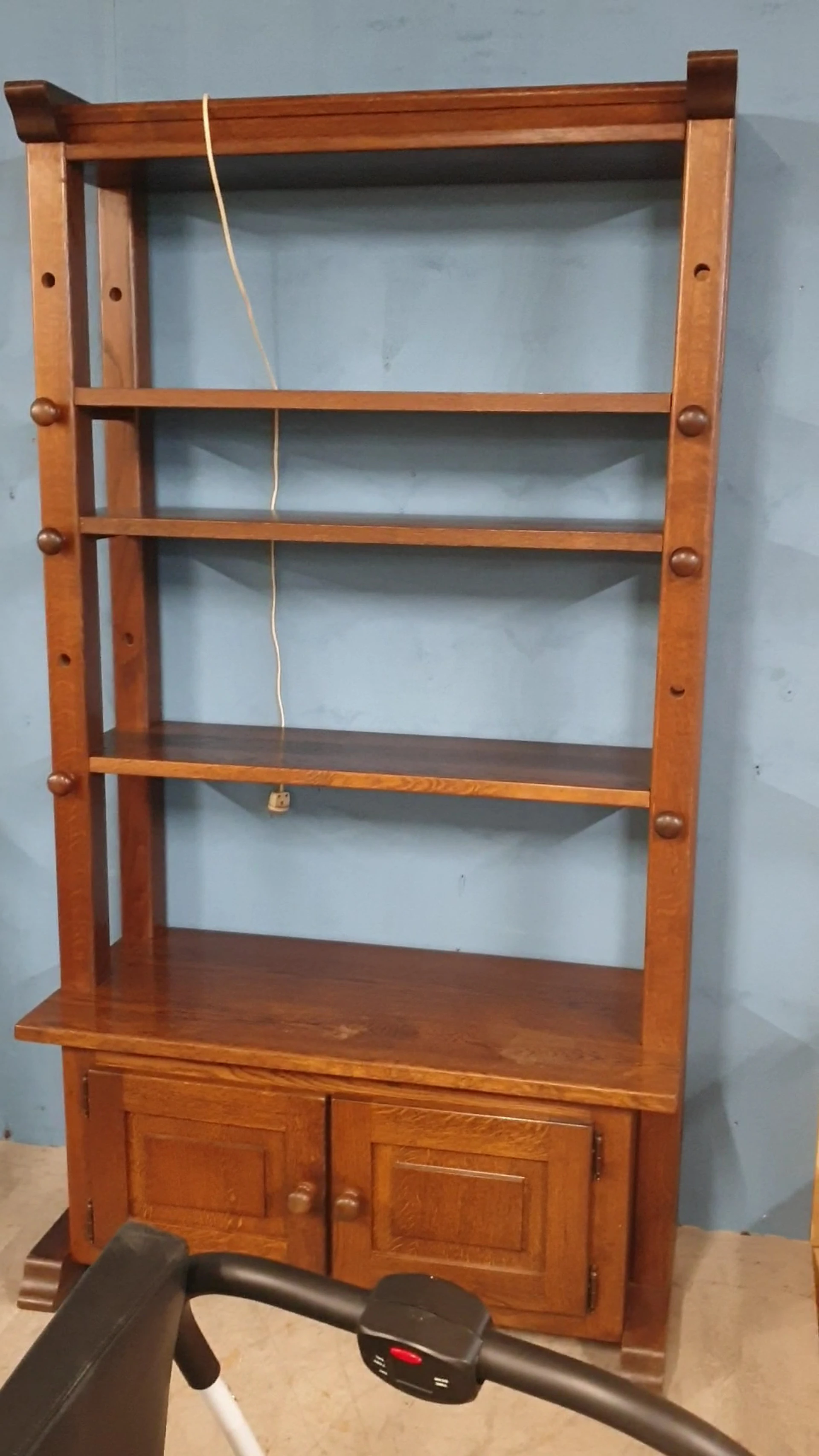 Houten boekenkast met vier legplanken tegen witte muur
