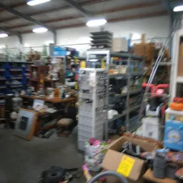 Winkelvloer met stellingen, dozen en diverse spullen in een kringloopwinkel
