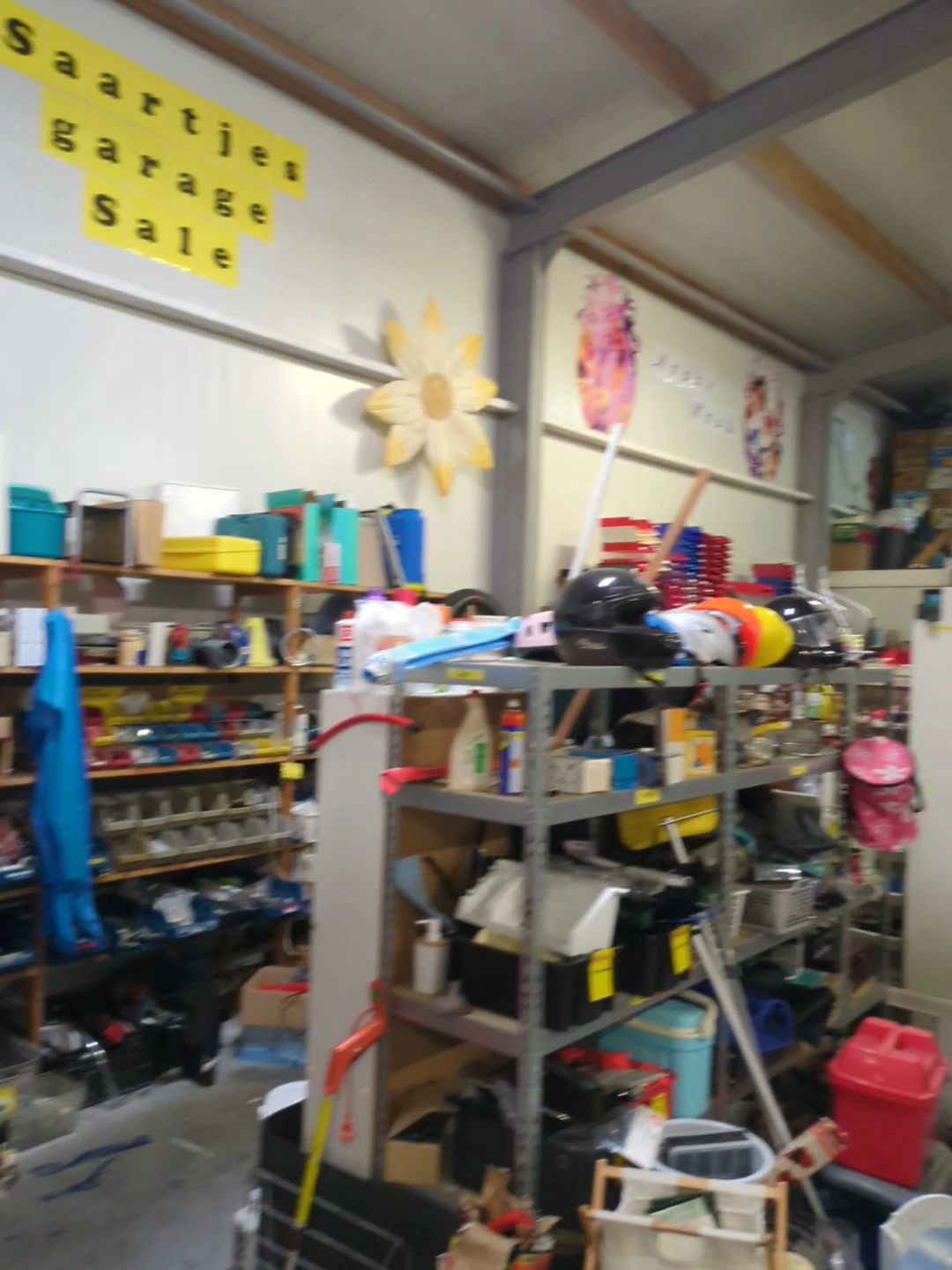 Rommelige kringloopwinkel met stellingen vol spullen, dozen en diverse artikelen
