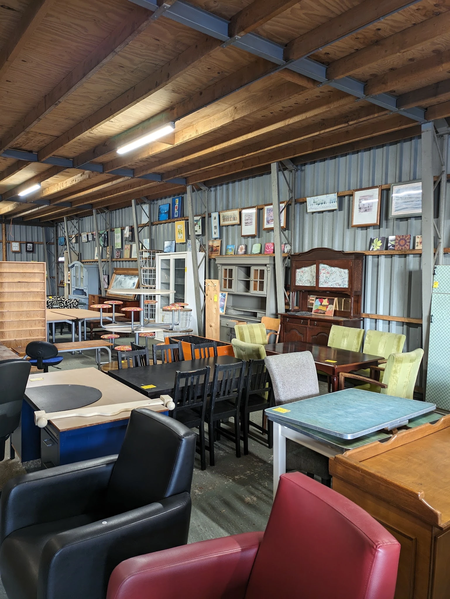 Winkelvloer met verschillende meubels, stellingen, stoelen en huishoudartikelen uitgestald