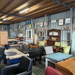Winkelvloer met verschillende meubels, stellingen, stoelen en huishoudartikelen uitgestald