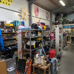Volle stellingen en rekken met diverse goederen in een kringloopwinkel