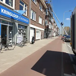 Gevel van Kringloop Scheveningen aan een straat met fietsen voor de ingang