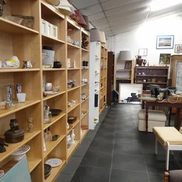 Winkelvloer met houten stellingen vol decoratieartikelen, meubels en spullen