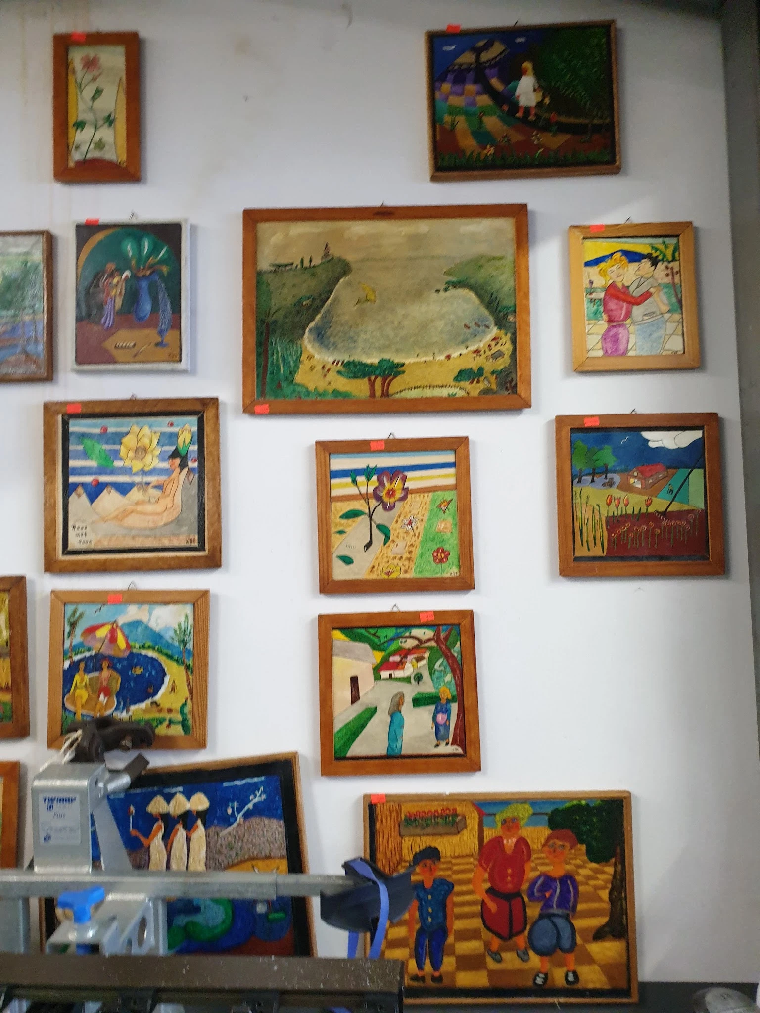 Verzameling van ingelijste kunstwerken en schilderijen aan de muur, waaronder dieren en landschappen in verschillende stijlen