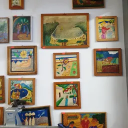 Verzameling van ingelijste kunstwerken en schilderijen aan de muur, waaronder dieren en landschappen in verschillende stijlen