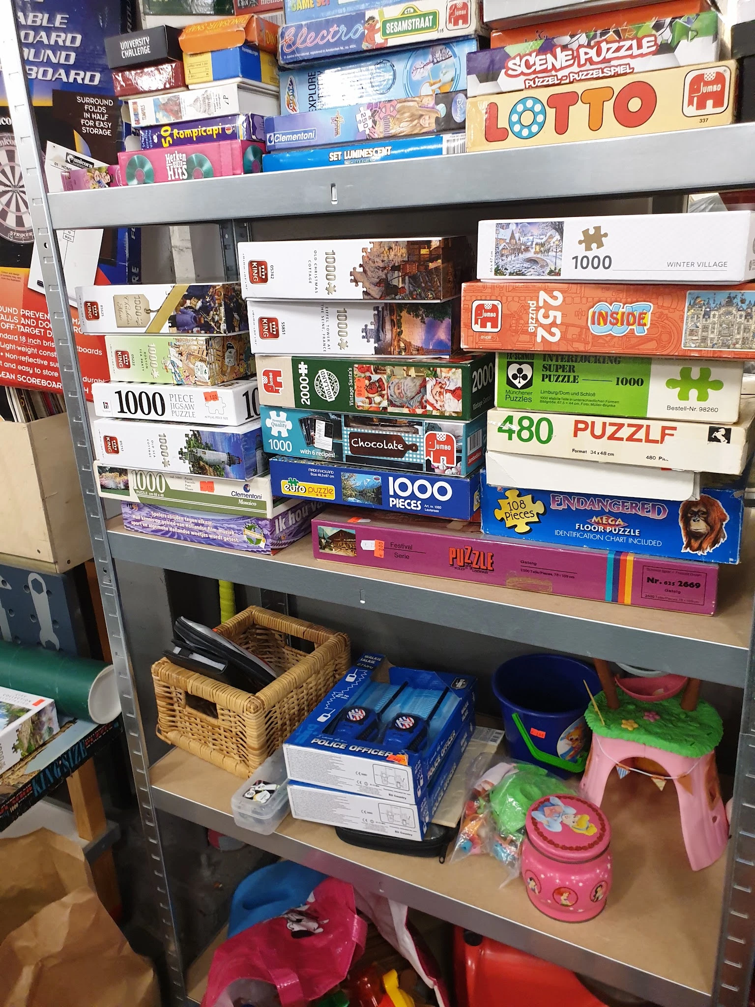 Stellingkast met stapels puzzels en bordspellen in verschillende formaten en kleuren