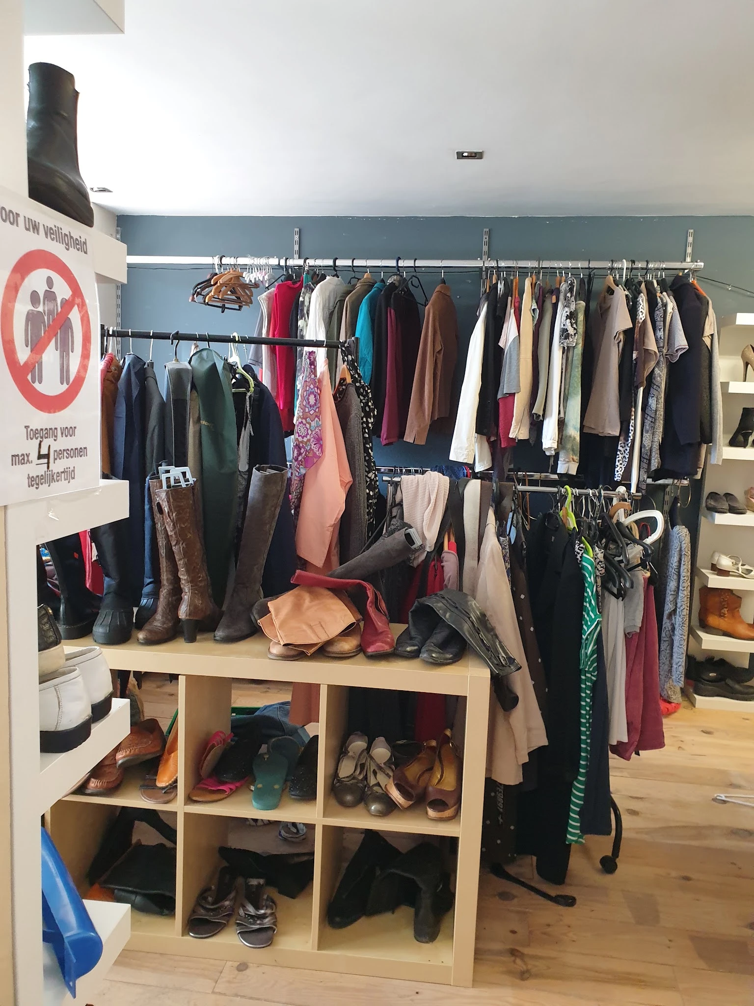 Kledingrekken en stellingen met tweedehands kleding, schoenen en accessoires