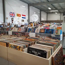 Uitgestalde vinyl records en LP's in dozen op tafels in de winkelruimte