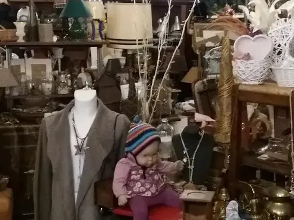 Kringloopwinkelinterieur met mannequin, decoratieve objecten, kasten en diverse spullen op stellingen