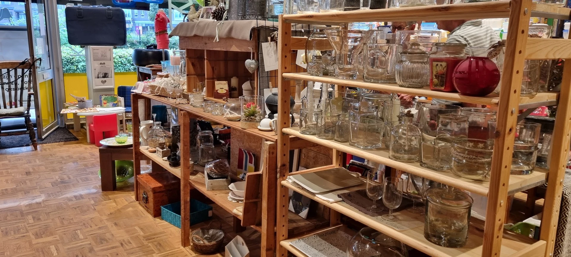 Houten stellingen en rekken vol met glazen potten, jampotten en glazen voorraadcontainers