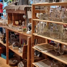 Houten stellingen en rekken vol met glazen potten, jampotten en glazen voorraadcontainers