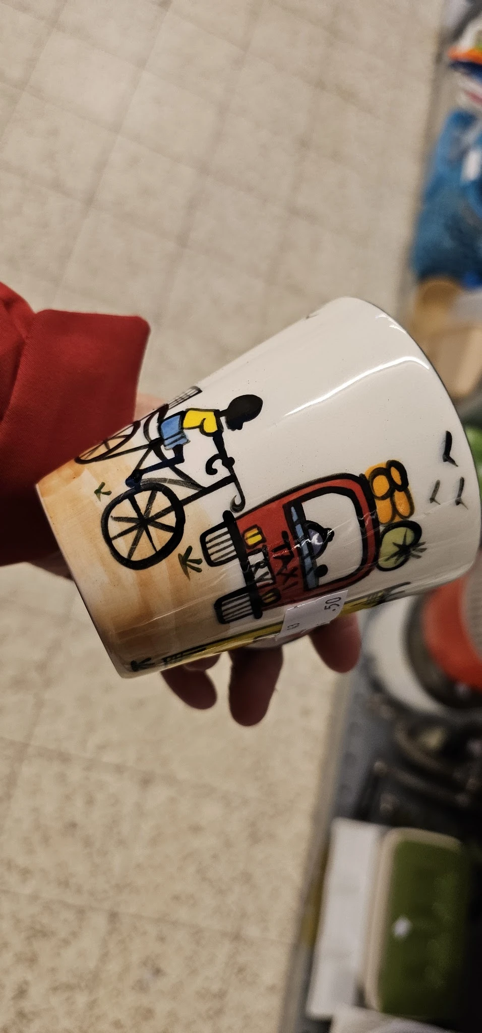 Witte mok met kleurrijke cartoon-achtige tekeningen van personen op een fiets en met gereedschap