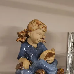Houten beeldje van een meisje in blauwe jurk met gouden haar, close-up